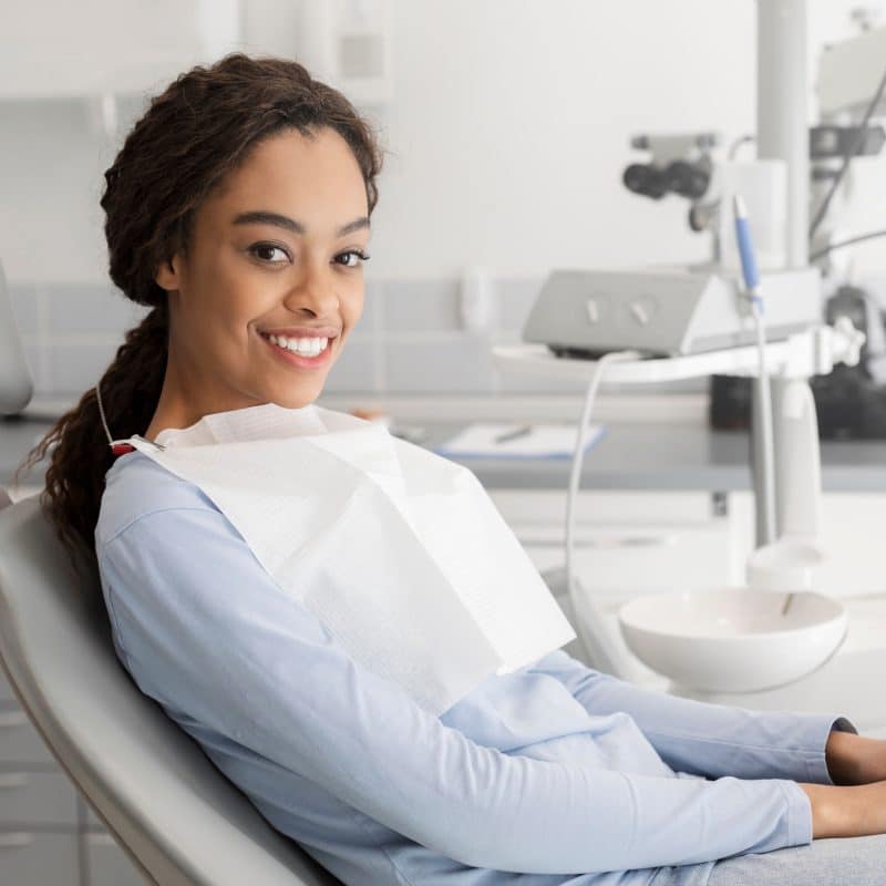 Young,Black,Lady,Sitting,In,Dentist,Chair,And,Smiling,At