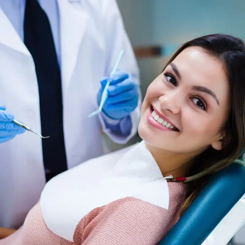 Dentist and happy female patient in dental clinic for specialty endodontics