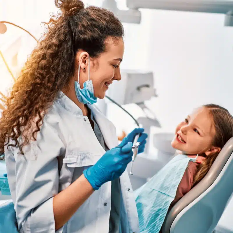 pediatric dentist with child patient in modern pediatric dentistry office